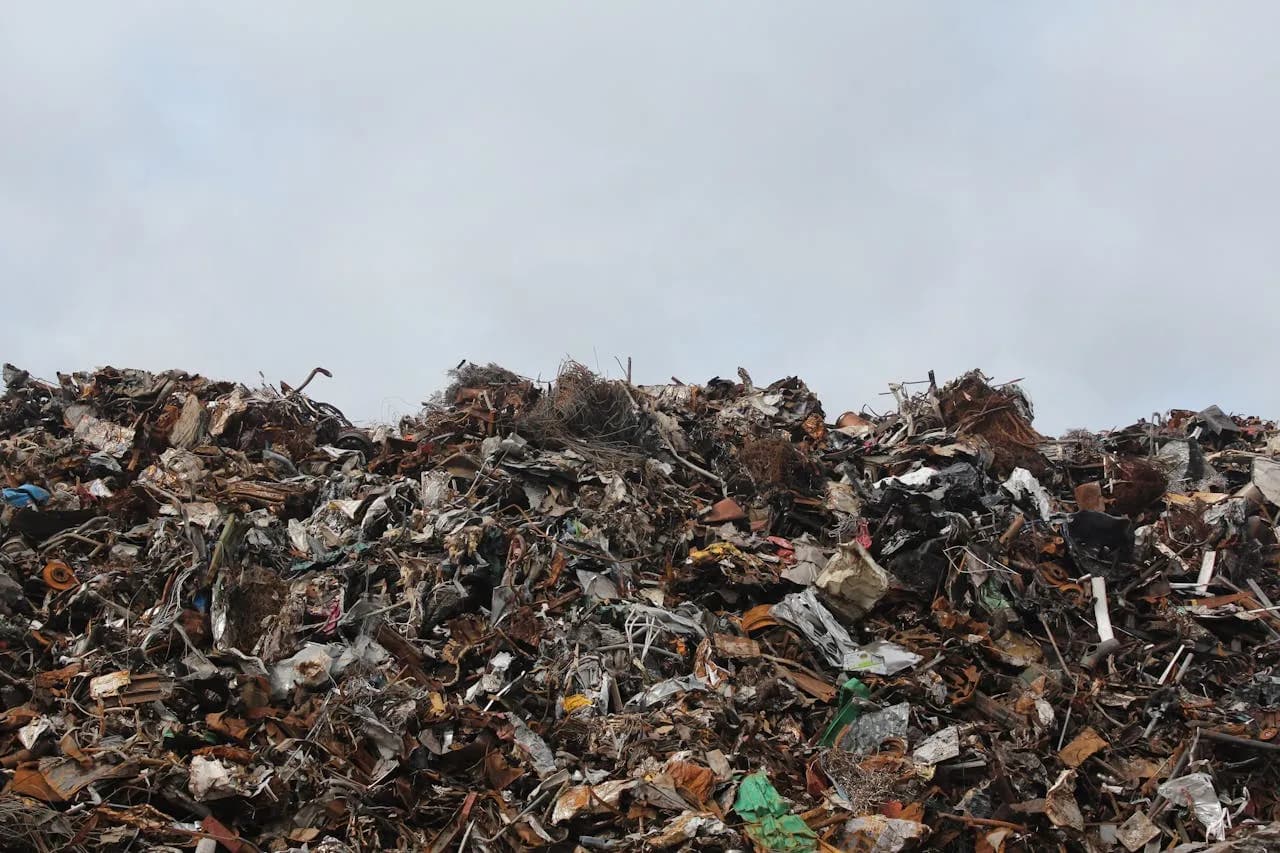 Pile of mixed waste and debris at a landfill, highlighting environmental challenges and waste management issues.